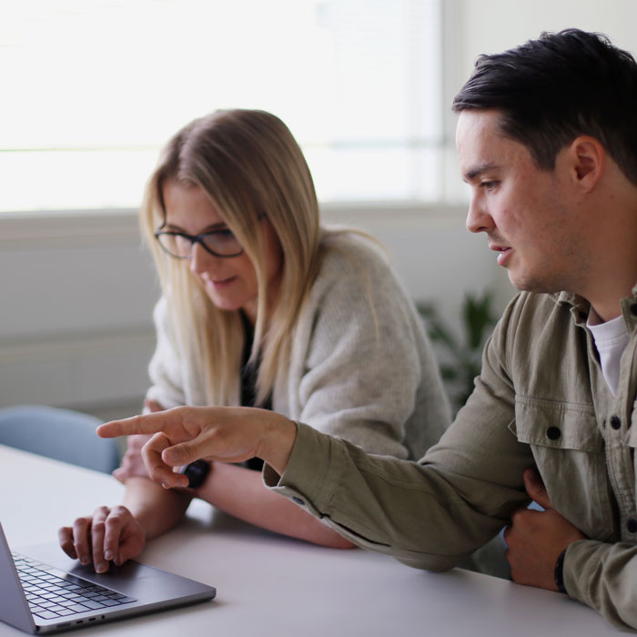 CleanManager colleagues collaborating at a desk, sharing knowledge and solving tasks together.